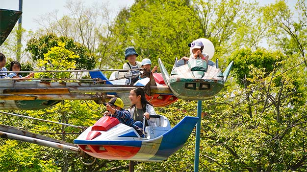 飛行機型のアトラクションを楽しむ人達